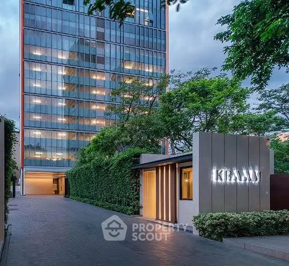 Modern high-rise building with lush greenery and sleek entrance