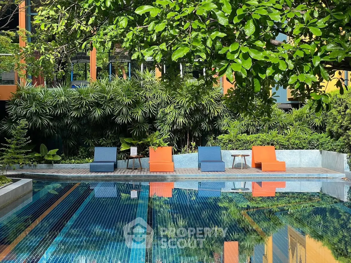 Luxurious poolside area with vibrant lounge chairs and lush greenery, perfect for relaxation and leisure.