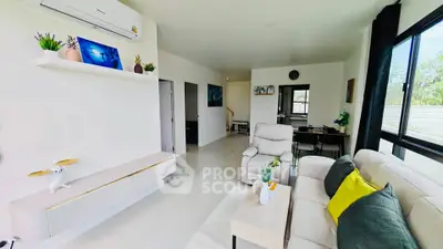 Modern living room with sleek furniture and large windows offering natural light.