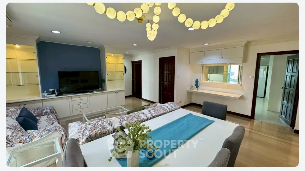 Spacious living room with elegant decor and modern lighting in a stylish apartment.