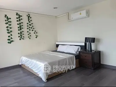 Modern bedroom with sleek design, featuring a comfortable bed, stylish nightstand, and air conditioning unit.
