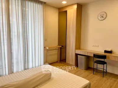 Modern bedroom with wooden flooring, sleek wardrobe, and minimalist decor.