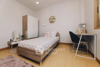 Charming bedroom with cozy decor, featuring a single bed, study desk, and ample storage, perfect for a peaceful retreat.