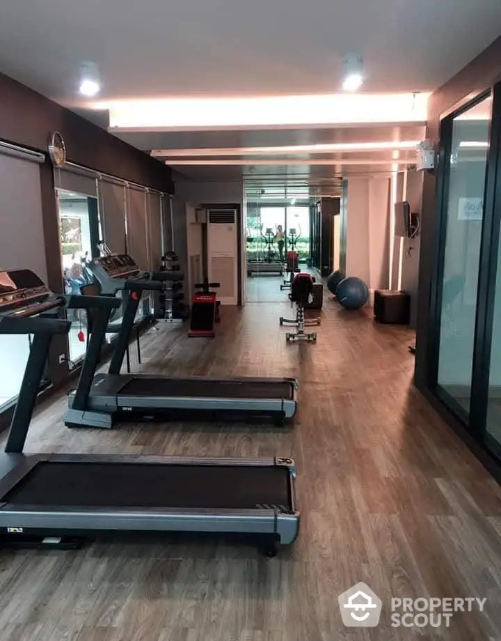 Modern gym with treadmills and exercise equipment in a sleek residential building.