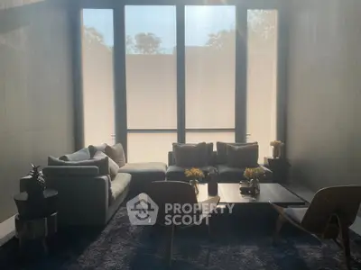 Luxurious living room with modern furniture and large windows, offering a serene and stylish ambiance.
