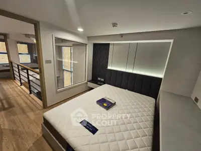 Modern bedroom with stylish decor and large window in a contemporary apartment.