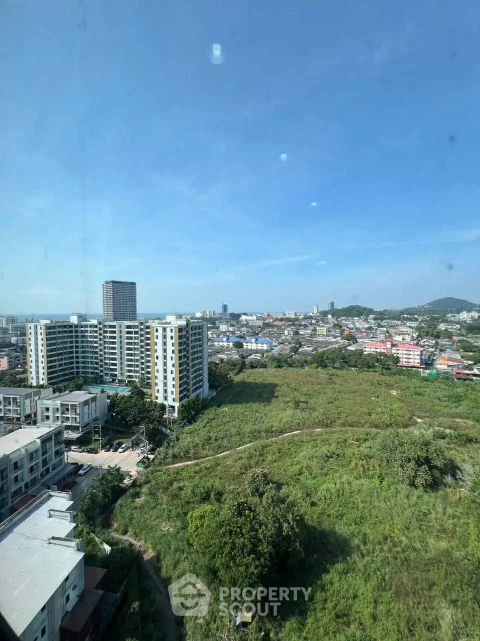 Stunning cityscape view from high-rise building showcasing urban development and greenery.