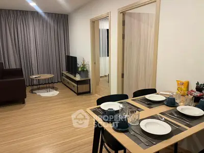 Modern living room with dining area, featuring stylish decor and cozy ambiance.