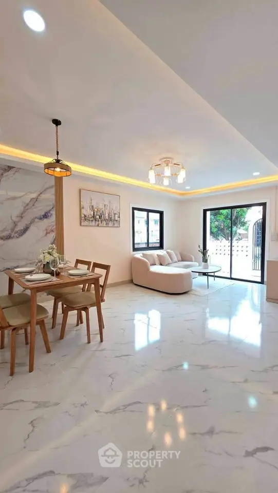Elegant living room with marble flooring, modern lighting, and stylish dining area in a contemporary home.