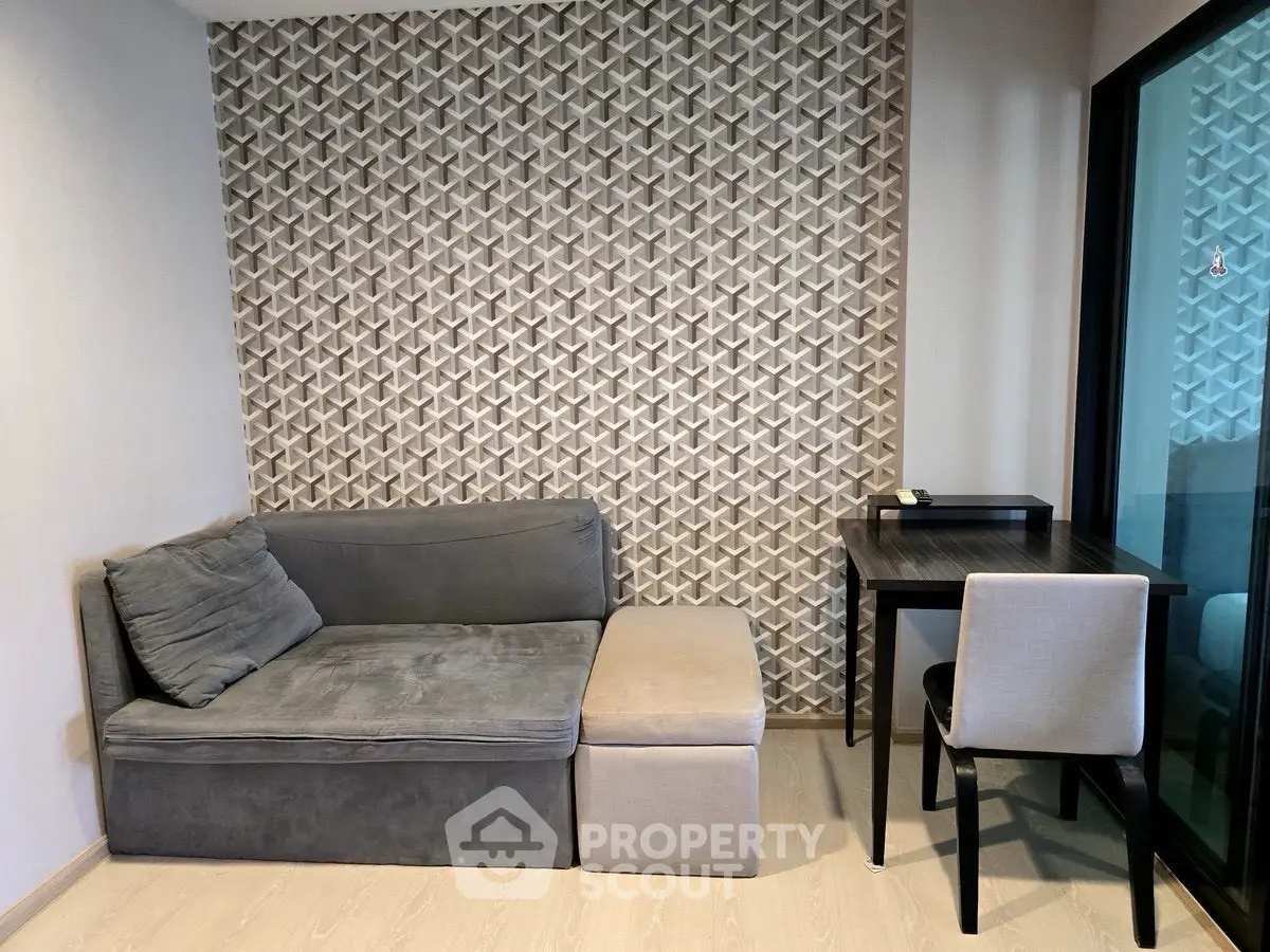 Modern living room with stylish geometric wall design and cozy seating area.