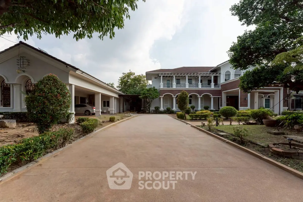 Elegant colonial-style home with spacious driveway and lush garden