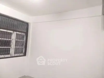 Minimalist empty room with barred windows and white walls, ideal for customization.