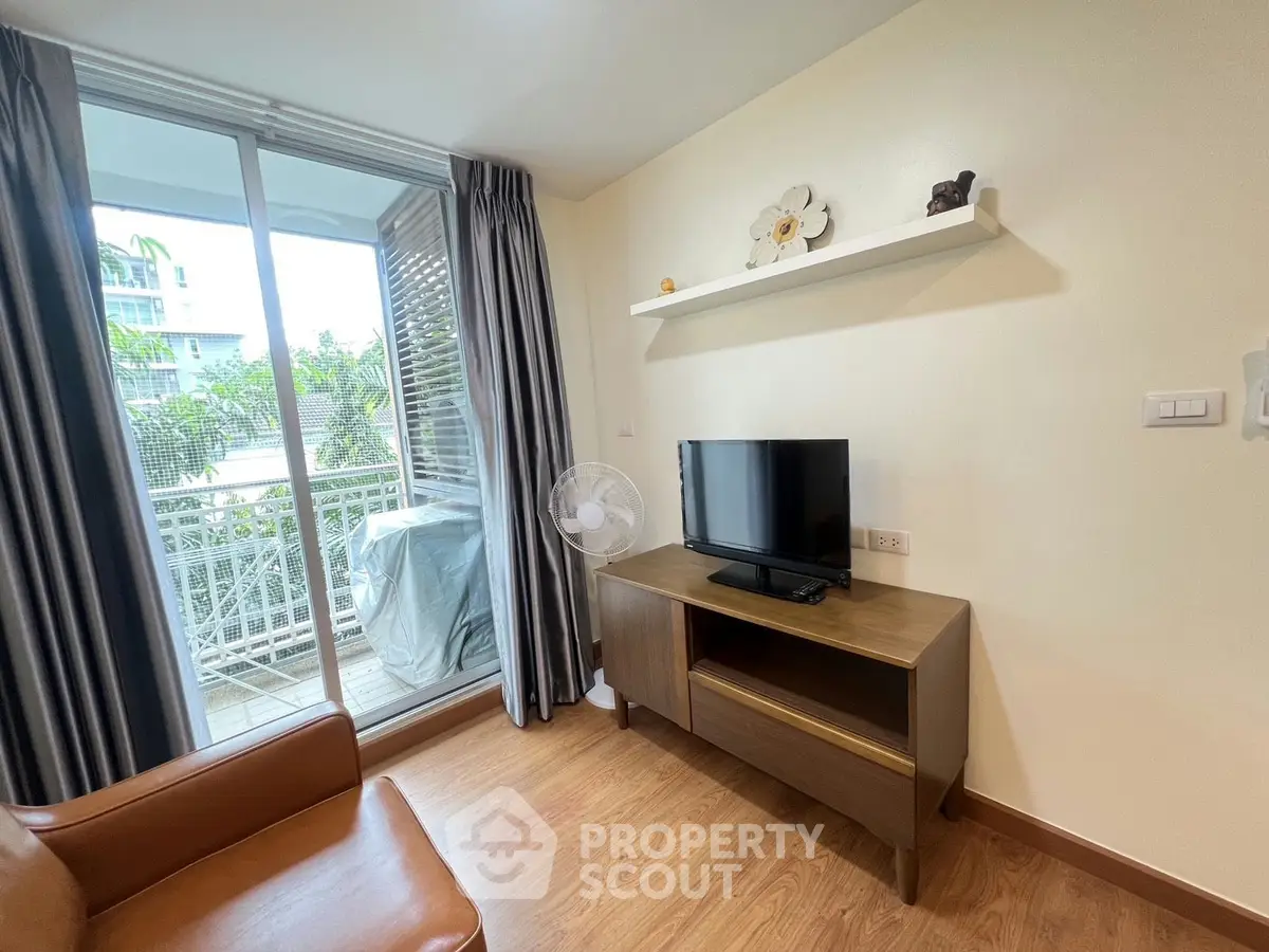 Cozy living room with balcony access and modern furnishings in a stylish apartment.