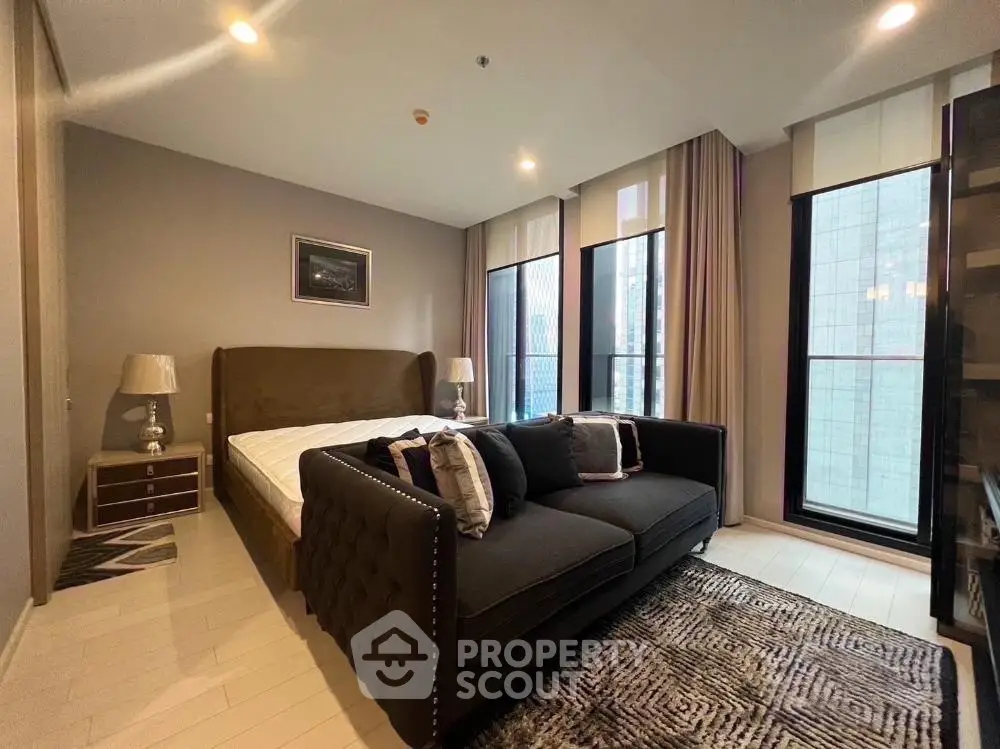 Luxurious bedroom with modern decor and large windows offering city views.