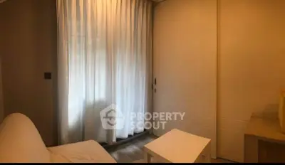 Cozy living room with white sofa and curtains, perfect for relaxation.