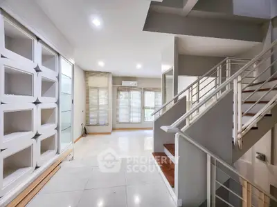 Spacious modern living room with elegant staircase and built-in shelving