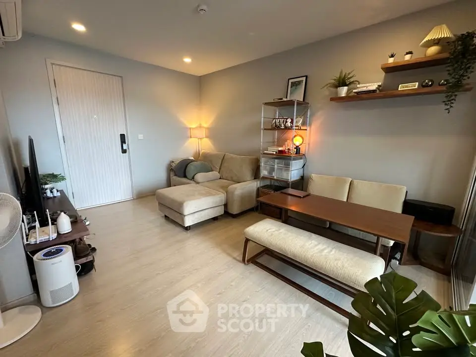 Modern living room with cozy beige sofa, wooden furniture, and stylish decor