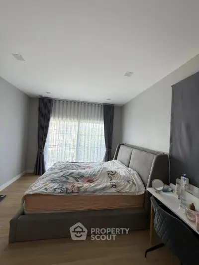 Spacious bedroom with modern decor and large window for natural light
