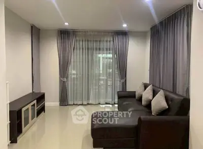 Spacious living room with elegant curtains and modern sofa, perfect for relaxation and entertainment.