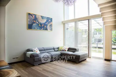 Spacious living room with modern decor and large windows overlooking garden.