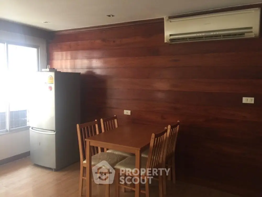 Cozy dining area with wooden paneling and air conditioning in modern apartment.