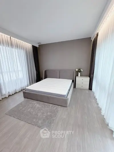 Spacious modern bedroom with large windows and elegant decor