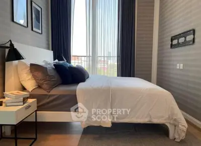 Modern bedroom with stylish decor and large window offering natural light