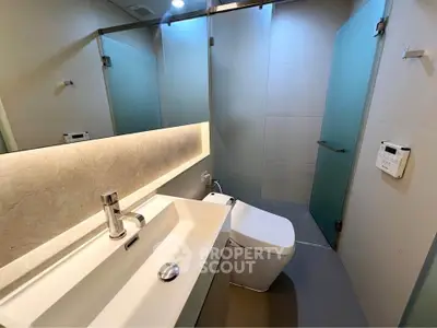 Modern bathroom with sleek fixtures and frosted glass doors