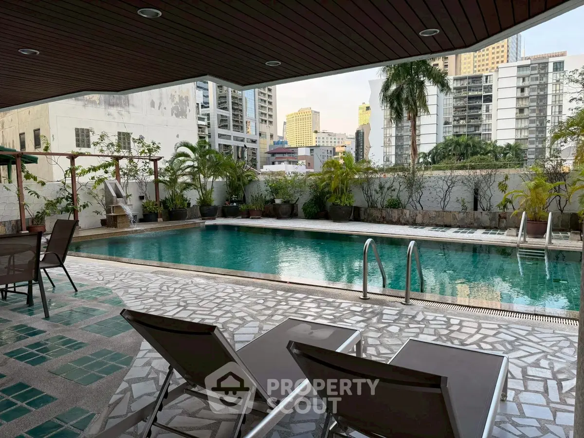 Luxurious poolside view in urban residential complex with modern amenities.
