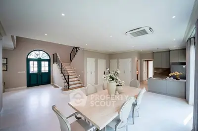 Spacious open-plan living and dining area with elegant decor and modern kitchen.