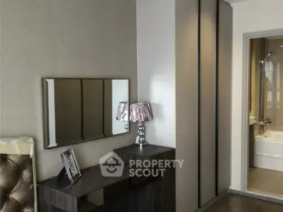 Modern bedroom with stylish decor and adjacent bathroom view.