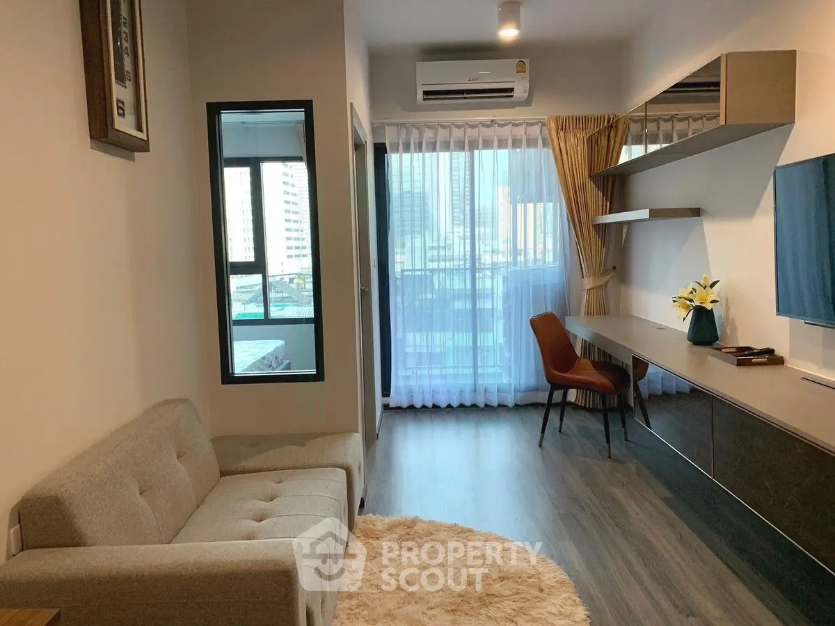 Modern living room with stylish decor and city view, featuring a cozy sofa and elegant workspace.