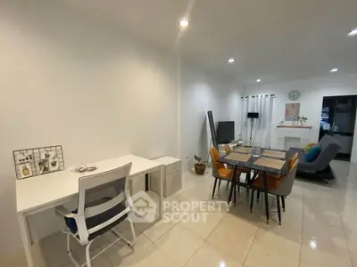 Modern open-plan living and dining area with sleek furniture and bright lighting.