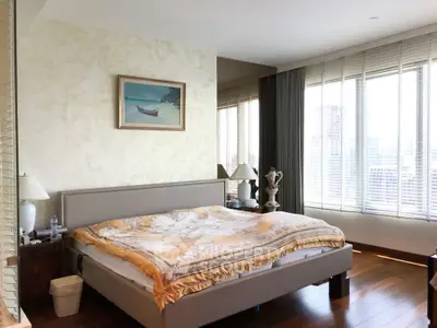 Spacious bedroom with large windows and elegant decor in a modern apartment.