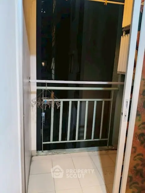 Cozy small balcony with tiled floor and railing, perfect for urban living.