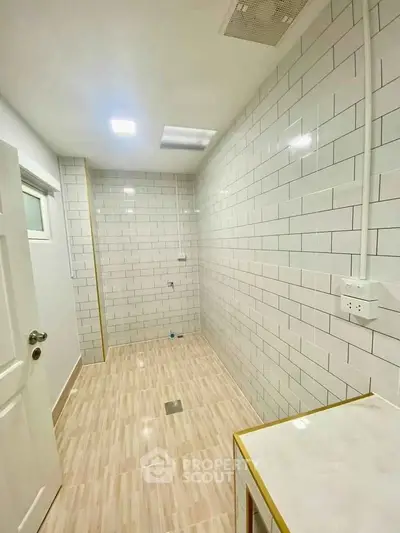 Spacious tiled bathroom with modern fixtures and bright lighting