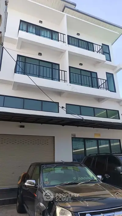 Modern multi-story building with sleek balconies and large windows, ideal for urban living.