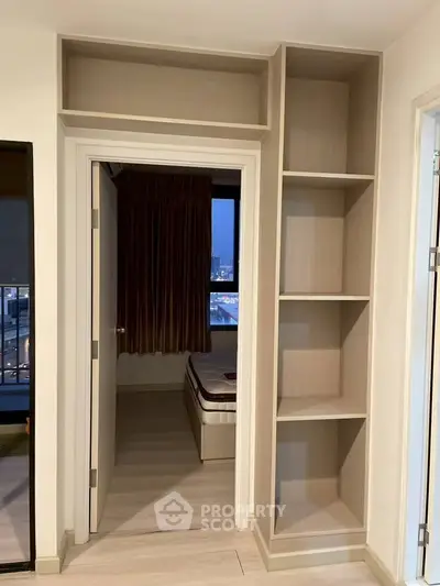 Modern bedroom with built-in shelving and city view, perfect for urban living.