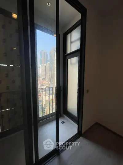 Modern apartment balcony with city skyline view and glass doors