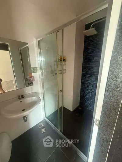 Modern bathroom with sleek shower and stylish sink in contemporary home.