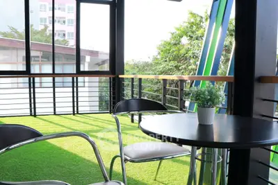 Charming balcony with lush green artificial grass and modern furniture, perfect for relaxation.