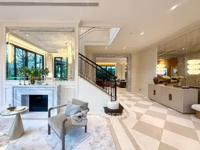 Luxurious living room with elegant decor, marble accents, and large windows offering a serene garden view.