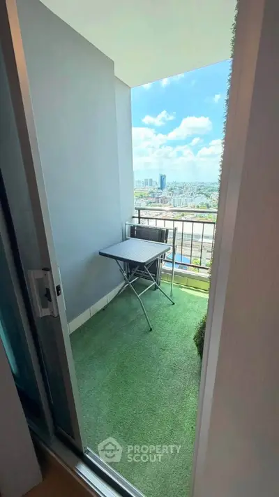 Charming balcony with artificial grass and city view, perfect for relaxation and enjoying the skyline.