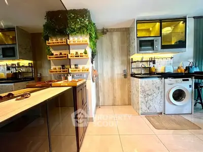 Modern kitchen with marble countertops, built-in appliances, and lush greenery accents.