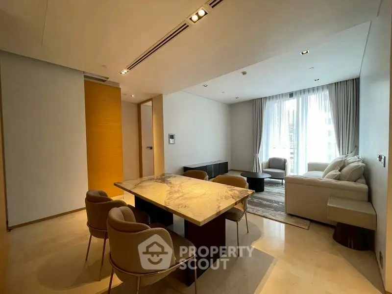 Luxurious modern living room with elegant marble dining table and cozy seating area.