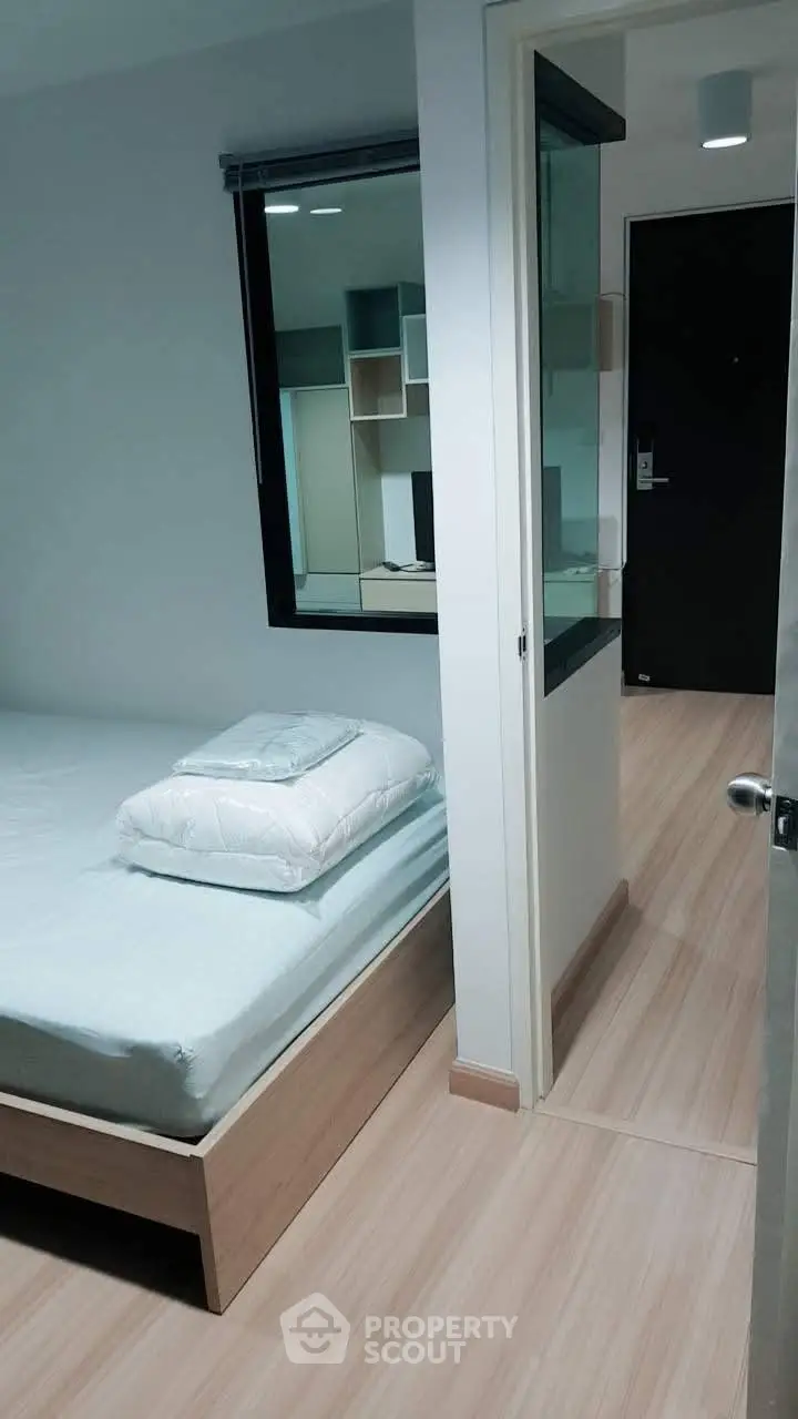 Modern bedroom with minimalist design and wooden flooring in a cozy apartment.