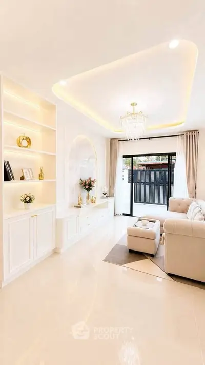 Luxurious living room with elegant chandelier and modern decor, featuring a cozy sofa and built-in shelving.