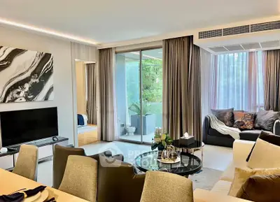 Spacious modern living room with elegant decor and large windows overlooking greenery.