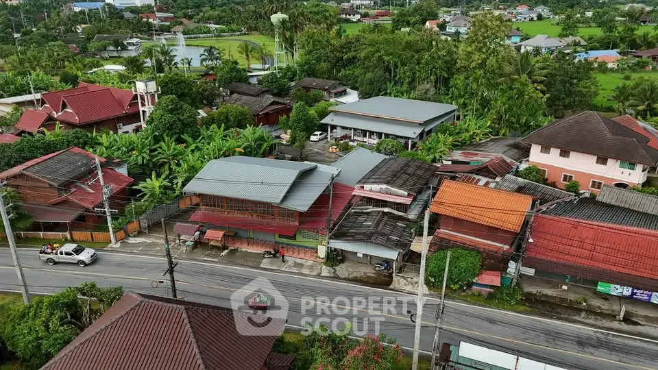 Charming aerial view of a serene residential neighborhood with lush greenery and traditional houses.