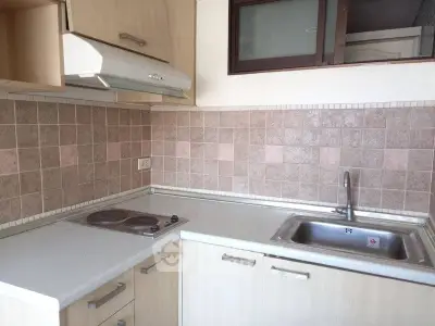 Modern kitchen with electric stove and sleek cabinetry in a compact layout.